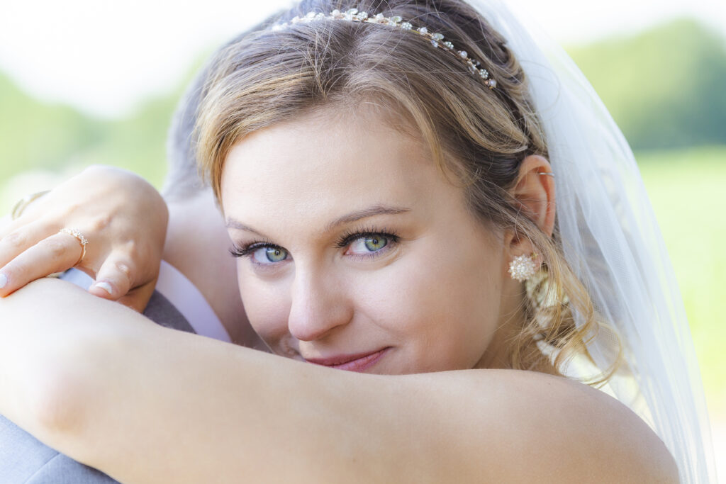 Bride gently smiles as she hugs her groom after their wedding ceremony.